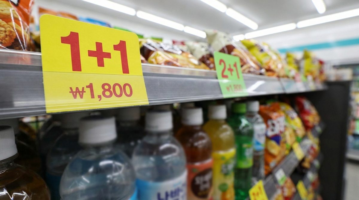 1+1 Korea shelf tag close-up - yellow 1+1 price tag on a Korean convenience store shelf